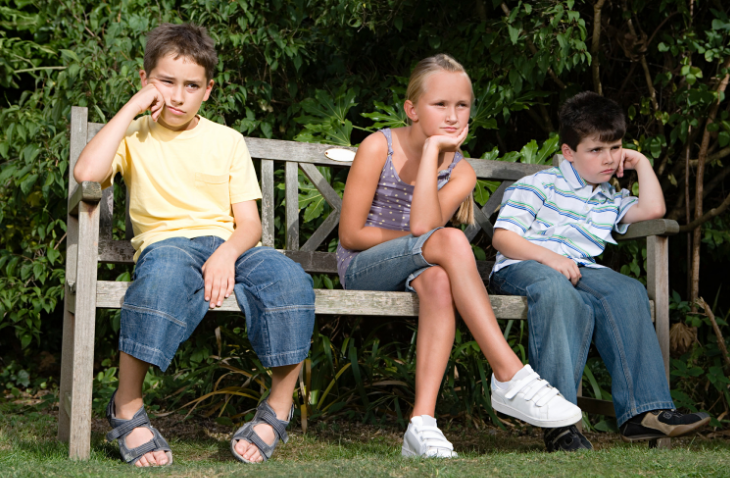 bored children sitting on a bench
