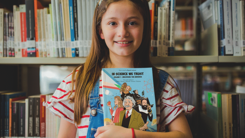 Girls holding In Science We Trust Book